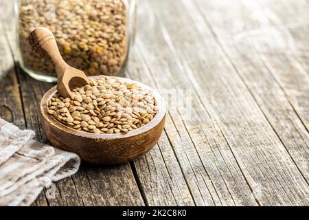 Ungekochte braune Linsen. Rohleguminosen in Schüssel auf Holztisch. Stockfoto