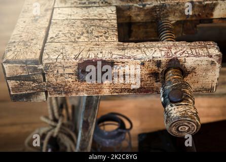 Eine alte Holzwerkbank, eine Werkbank in einer Werkstatt. Stockfoto