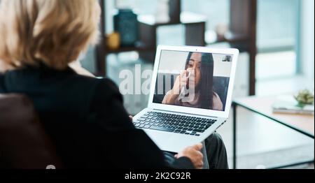 Eine Rettungsleine für das Leben unter Verschluss. Aufnahme einer jungen Frau, die eine Beratungsstunde mit einem Psychologen mit Hilfe eines Videokonferenztools hat. Stockfoto