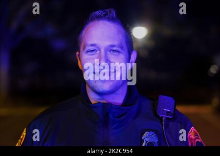 Beamter Freundlich. Beschnittenes Porträt eines hübschen jungen Polizisten auf Patrouille. Stockfoto