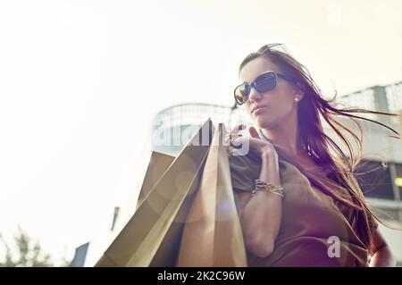 Fashionista für unterwegs. Eine stilvolle junge Frau, die in der Stadt einkaufen geht. Stockfoto