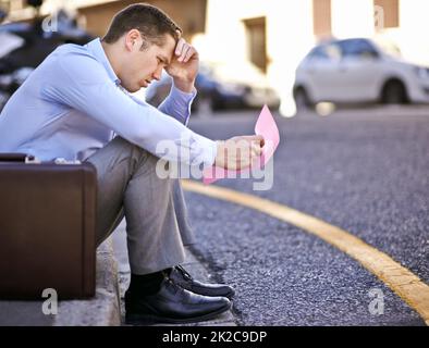 Ich hätte nie gedacht, dass mir das passieren würde. Ein Geschäftsmann, der einen rosafarbenen Slip hält, um seine Beschäftigung zu beenden. Stockfoto