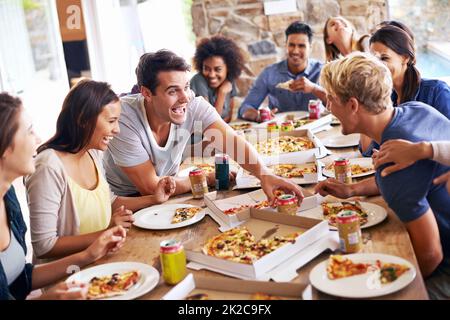 Sich für Pizza treffen. Eine kurze Aufnahme einer Gruppe von Freunden, die zusammen Pizza genießen. Stockfoto