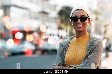 Einfach unvergleichlich... die Stadt erkunden. Eine kurze Aufnahme einer attraktiven jungen Frau, die einen Hijab und eine Sonnenbrille trägt, während sie die Stadt bereist. Stockfoto