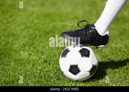 Kommt und bekommt es, wenn Ihr könnt. Zugeschnittenes Bild einer Fußballspielerin, die auf einem Fußball steht. Stockfoto