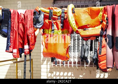 Trocknen im Sonnenlicht. Kurzer Schuss Rettungsschwimmer, die draußen an einer Wäscheleine hängen. Stockfoto