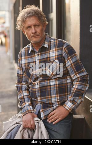 Lässige Eleganz. Porträt eines freundlich aussehenden Mannes mittleren Alters draußen. Stockfoto