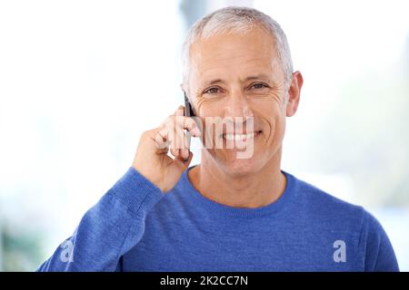 Mit Freunden und Familie in Kontakt bleiben. Ein reifer Mann, der ein angenehmes Telefongespräch führt. Stockfoto