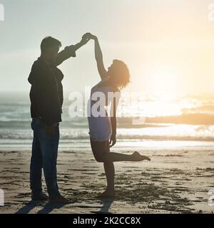 Deine Gegenwart lässt mein Herz tanzen. Aufnahme eines liebevollen jungen Paares, das seine Zeit am Strand genießt. Stockfoto