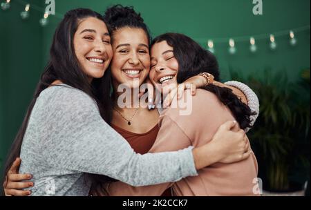 Waren wie eine Familie von Freunden. Aufnahme von drei glücklichen jungen Schwestern, die sich in einem Café umarmen. Stockfoto