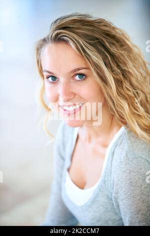 Süß und schön. Porträt einer hübschen jungen Blondine, die Sie süß anlächelt. Stockfoto