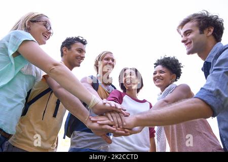 Sich gegenseitig motivieren. Aufnahme einer Gruppe von Studenten, die ihre Hände in einen Huddle legen. Stockfoto