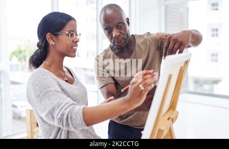 Hes ist der beste Kunstlehrer der Stadt. Ausgeschnittene Aufnahme einer Frau, die in einer Kunstklasse mit ihrem Lehrer spricht. Stockfoto