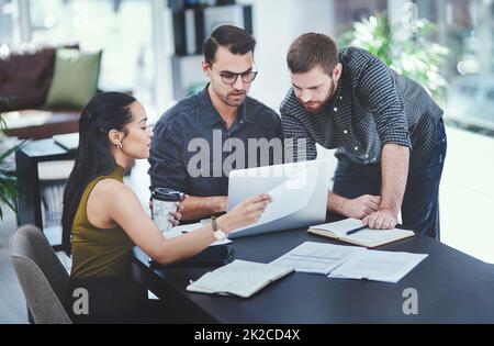 Ihre Köpfe als Innovatoren zusammenfügen. Aufnahme einer Gruppe junger Designer, die in einem Büro diskutieren. Stockfoto