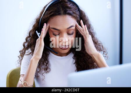 Es war ein überwältigender Tag. Aufnahme eines jungen Callcenter-Agenten, der gestresst in einem Büro arbeitet. Stockfoto