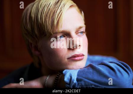 Sie fragen sich, was die Zukunft bringt. Nachdenklicher und hübscher junger blonder Kerl mit sehr blauen Augen. Stockfoto