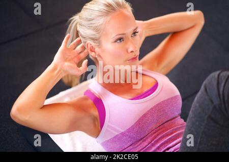 Eine schöne Frau, die Sit-ups macht. Stockfoto
