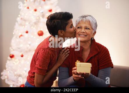 Das größte Geschenk ist das Schenken. Eine Mutter und Tochter tauschen an Weihnachten Geschenke aus. Stockfoto