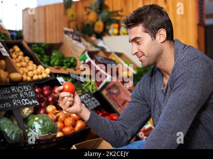 Nur das frischeste für ihn. Aufnahme eines jungen Mannes in einem Supermarkt, der frische Produkte einkauft. Stockfoto