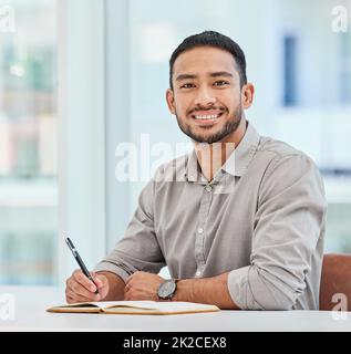 Entstehen meiner Arbeitswoche. Aufnahme eines jungen Geschäftsmannes, der Notizen in seinem Notizbuch macht. Stockfoto