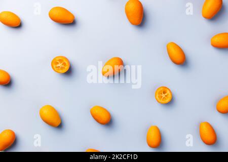 Hellblaue flache Lage mit Blick von oben auf frische reife Kumquat-Zitrusfrüchte Stockfoto