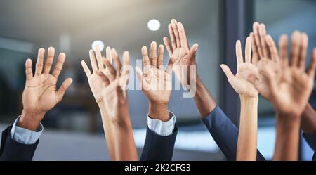 Wählen Sie uns aus. Ausgeschnittene Aufnahme einer Gruppe von Geschäftsleuten, die ihre Hände hochheben. Stockfoto