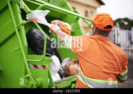 Ein mann Müll ... Ausgeschnittene Aufnahme eines Müllsammlungsarbeiters. Stockfoto