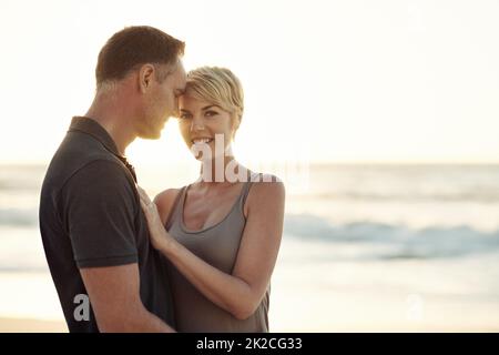 Die Sonne scheint auf ihre Liebe. Aufnahme eines reifen Paares, das einen Tag am Strand genießt. Stockfoto