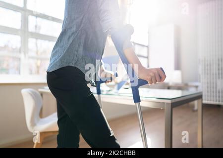 Arbeiter Mit Krücken Am Arbeitsplatz Oder Im Büro Stockfoto