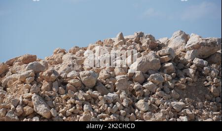 Foto eines großen Steinstapels auf der Baustelle, an der Küste des Mittelmeers an einem ruhigen Tag Stockfoto