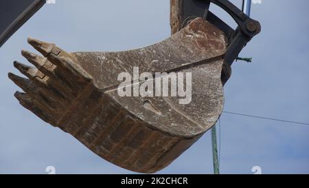 Baggerlader, der gegen den blauen Himmel steht Stockfoto