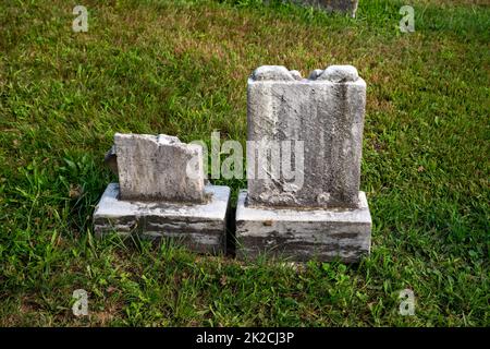 Zwei kleine uralte Grabsteine in grünem Gras Stockfoto