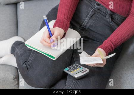 Hausrechnungen-Konzept. Junge Frau, die Rechnungen kalkuliert. Stockfoto