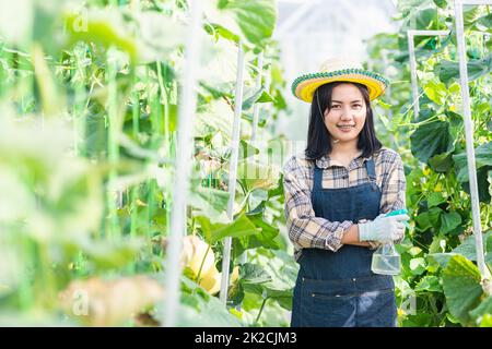 Die Farmerin steht mit gekreuzten Armen und lächelt Stockfoto