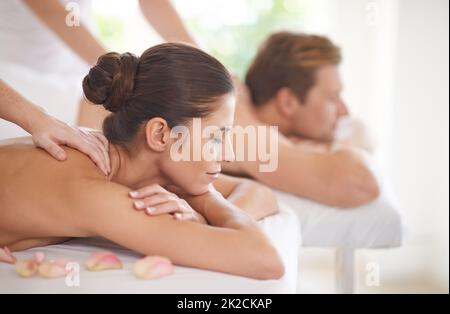 Genießen Sie einen Tag der Verwöhnung. Ein Mann und eine Frau liegen zusammen auf Massageliegen. Stockfoto