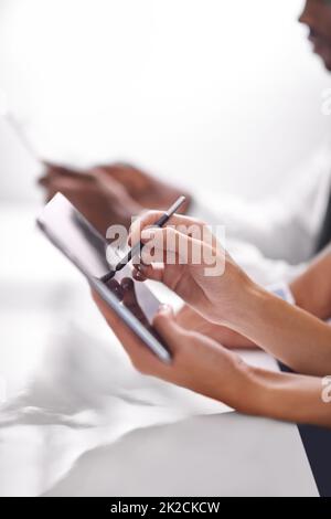 Erweiterung des Geschäftshorizonts mit Technologie. Eine kurze Aufnahme von zwei Geschäftsleuten, die ihre Touchpads verwendeten. Stockfoto