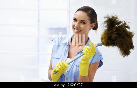 Entfernt Staub rechtzeitig. Aufnahme eines attraktiven Weibchen, das einen Federstauber hält.. Stockfoto