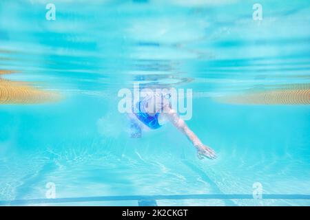 Schwimmen zu einer persönlichen Bestform. Unterwasseraufnahme einer Schwimmerin. Stockfoto