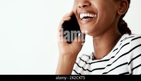 Bleiben Sie in Verbindung, bleiben Sie glücklich. Ausgeschnittene Aufnahme einer Frau mit einem Smartphone vor einem weißen Studiohintergrund. Stockfoto