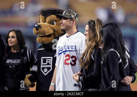 Der rechte Hockeyspieler Dustin Brown VON LA Kings, flankiert von Kings Maskottchen Bailey, bereitet sich darauf vor, den ersten Platz vor dem Spiel zwischen den Los Angeles Dodgers und den Arizona Diamondbacks während eines MLB Baseballspiels am Mittwoch, 21. September 2022, in Los Angeles zu werfen. Stockfoto