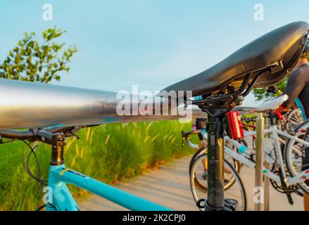 Fahrrad auf Aluminiumgestell im Park geparkt. Outdoor-Sport und Freizeitaktivitäten. Fahrrad am Fahrradparkplatz. Umweltfreundlich. Gesunder Lebensstil. Outdoor-Aktivitäten im Sommer. Extremsport. Stockfoto