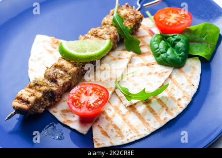 Kräuterspieß mit Pita-Brot, Tomaten und Limette Stockfoto