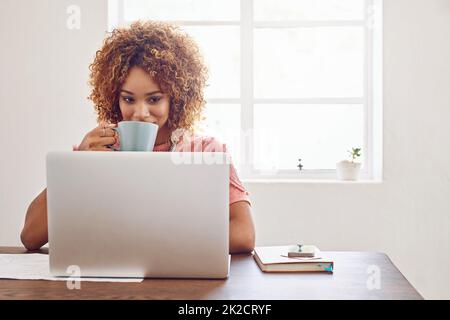 Wir lassen uns von der Technologie inspirieren und motivieren. Aufnahme einer Designerin, die Kaffee getrunken hat, während sie an ihrem Laptop arbeitete. Stockfoto