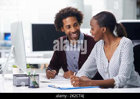 Genießen Sie eine großartige Arbeitsbeziehung. Aufnahme von zwei Kollegen, die in einem Büro sitzen. Stockfoto