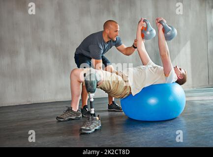 Konzentrieren Sie sich auf den Oberkörper. Studioaufnahme eines jungen Amputierten, der in einem Fitnessstudio trainiert. Stockfoto