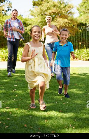 Eine tolle Zeit mit seiner Familie. Eine Frontansicht einer glücklichen Familie, die an einem sonnigen Tag im Park spielt. Stockfoto