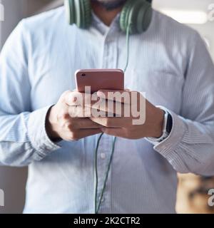 All das geschieht in den sozialen Medien. Ausgeschnittene Aufnahme eines Geschäftsmannes mit einem Smartphone in einem modernen Büro. Stockfoto