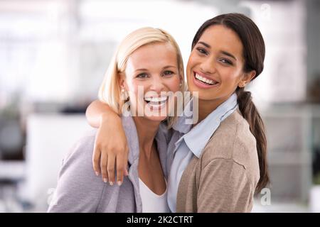 Ich liebe es, mit ihr zu arbeiten. Beschnittenes Porträt von zwei Geschäftsfrauen, die im Büro stehen. Stockfoto
