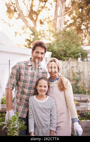 Unsere ganze Familie ist organisch geworden. Porträt einer glücklichen Familie, die in ihrem Hinterhof zusammen gärtelt. Stockfoto