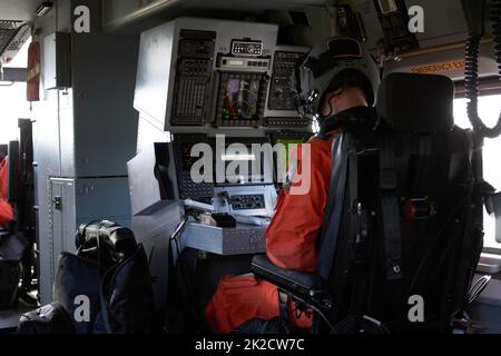 Die Hölle flieg dich in Sicherheit. Junger männlicher Pilot konzentriert sich in seinem Cockpit, während er sein Flugzeug fliegt. Stockfoto